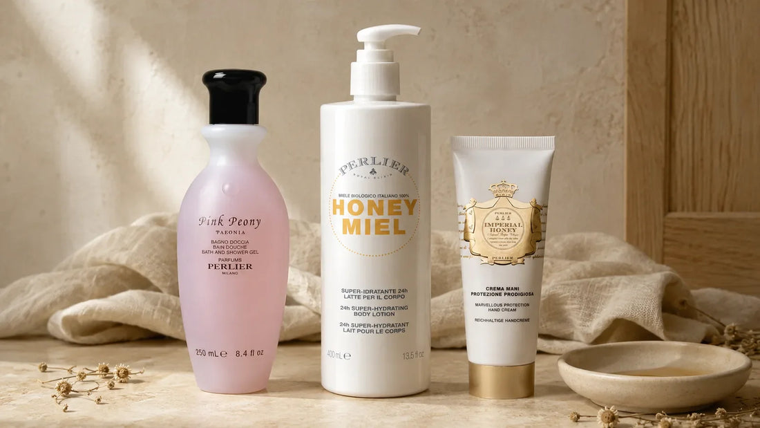 The Honey Miel shower gel, body lotion and hand cream in graduated height on a bone surface — one honeyed scent in three forms.